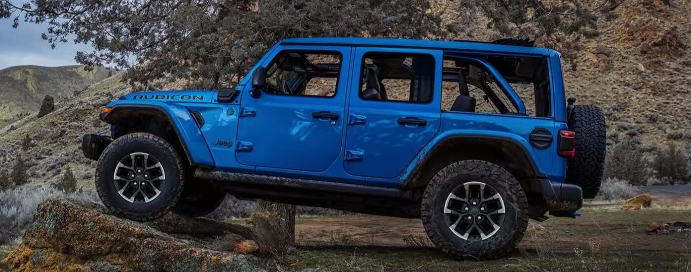 A blue 2025 Jeep Wrangler Rubicon parkedd off-road.