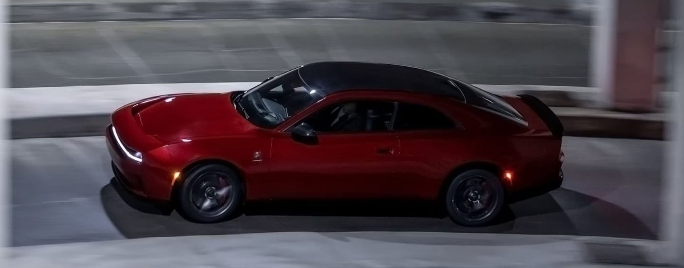 A red 2025 Dodge Charger Daytona from the side.