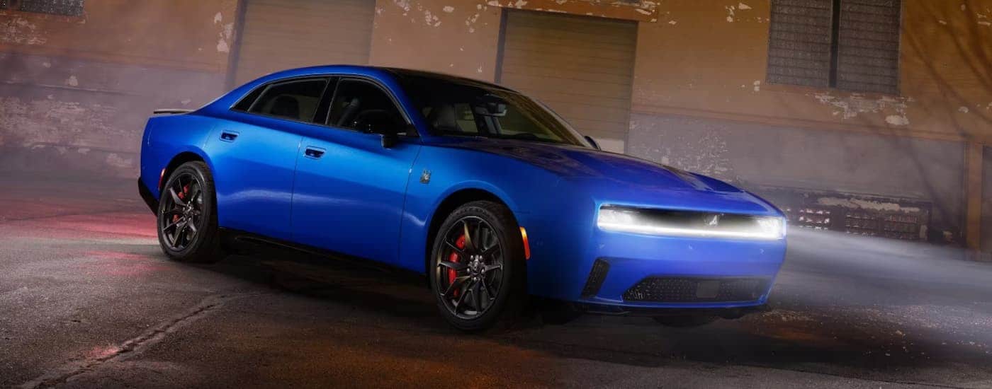 A blue 2026 Dodge Charger parked with its headlights on