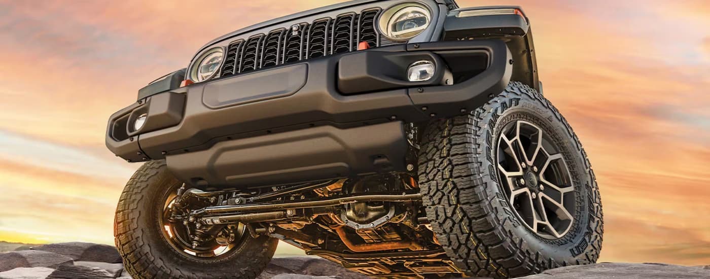 Front of a 2026 Jeep Gladiator driving up a hill
