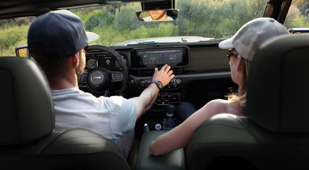 A couple using the infotainment system in a 2026 Jeep Gladiator for sale in Miami