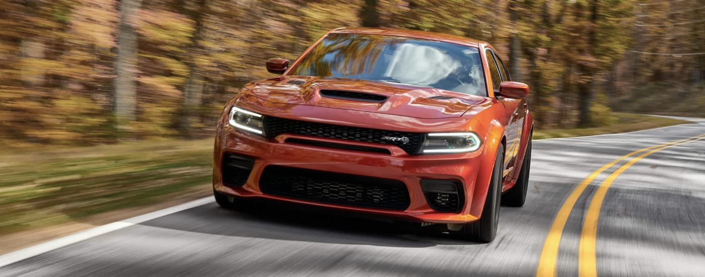 Orange 2022 Dodge Charger SR driving to a Dodge dealer near North Miami Beach