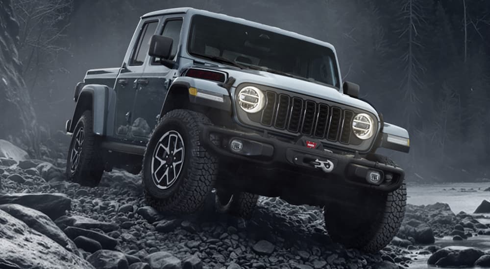 A gray 2026 Jeep Gladiator Shadow Ops off-roading on rocks