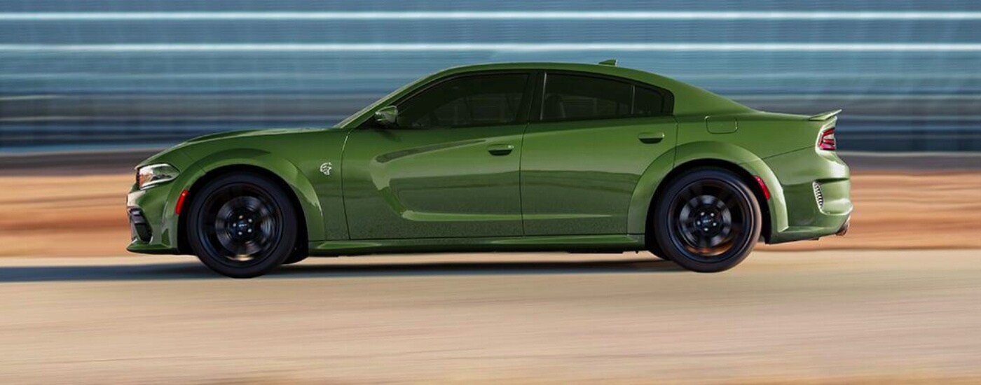 A green 2020 Dodge Charger is driving to a Dodge dealer.