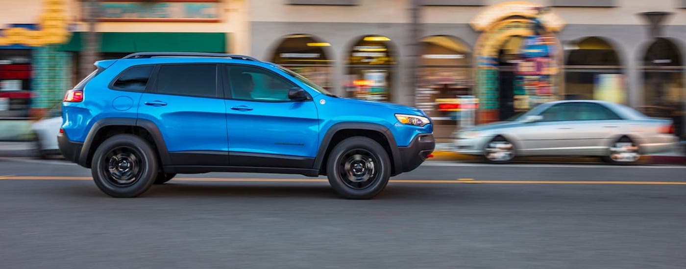 A blue 2022 Jeep Cherokee after leaving a used car dealer.