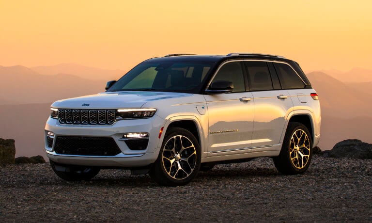 Orange colored mountain scene featuring a 2024 Jeep Grand Cherokee