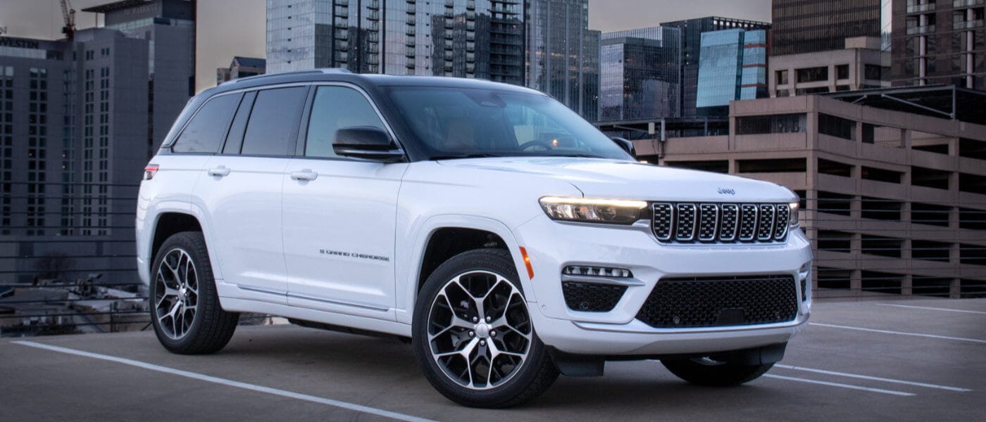 2024 Jeep Grand Cherokee parked in front of a city skyline