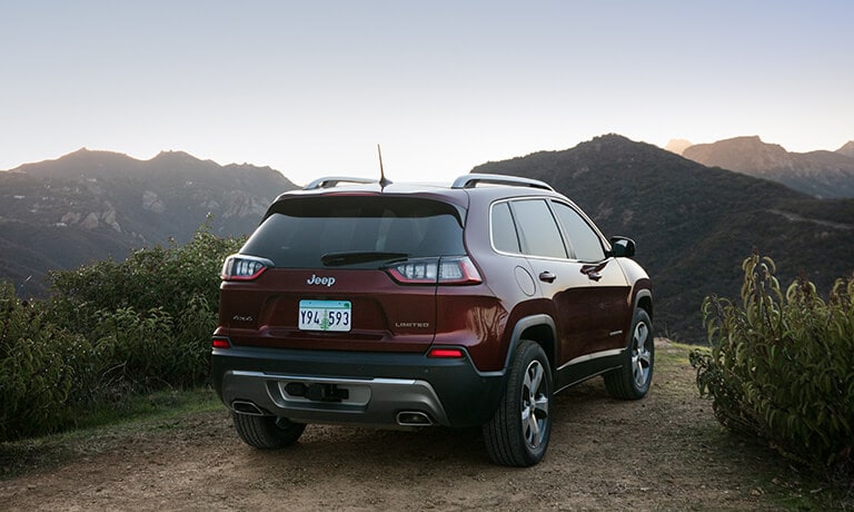 2020 Jeep Cherokee in maroon exterior driving up mountains