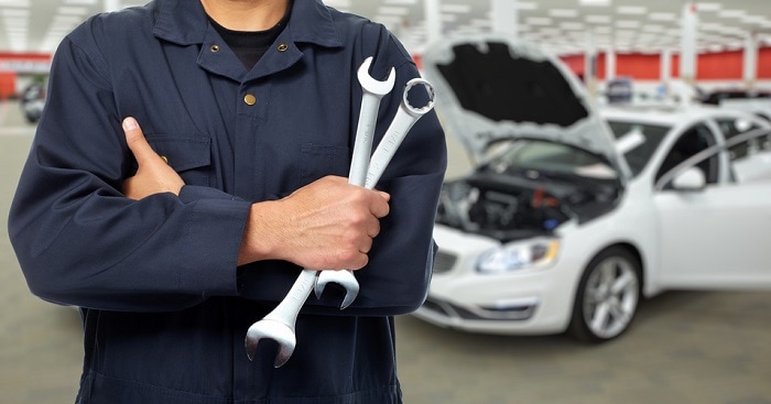 Mechanic_Holding_Wrench_By_Car.jpg