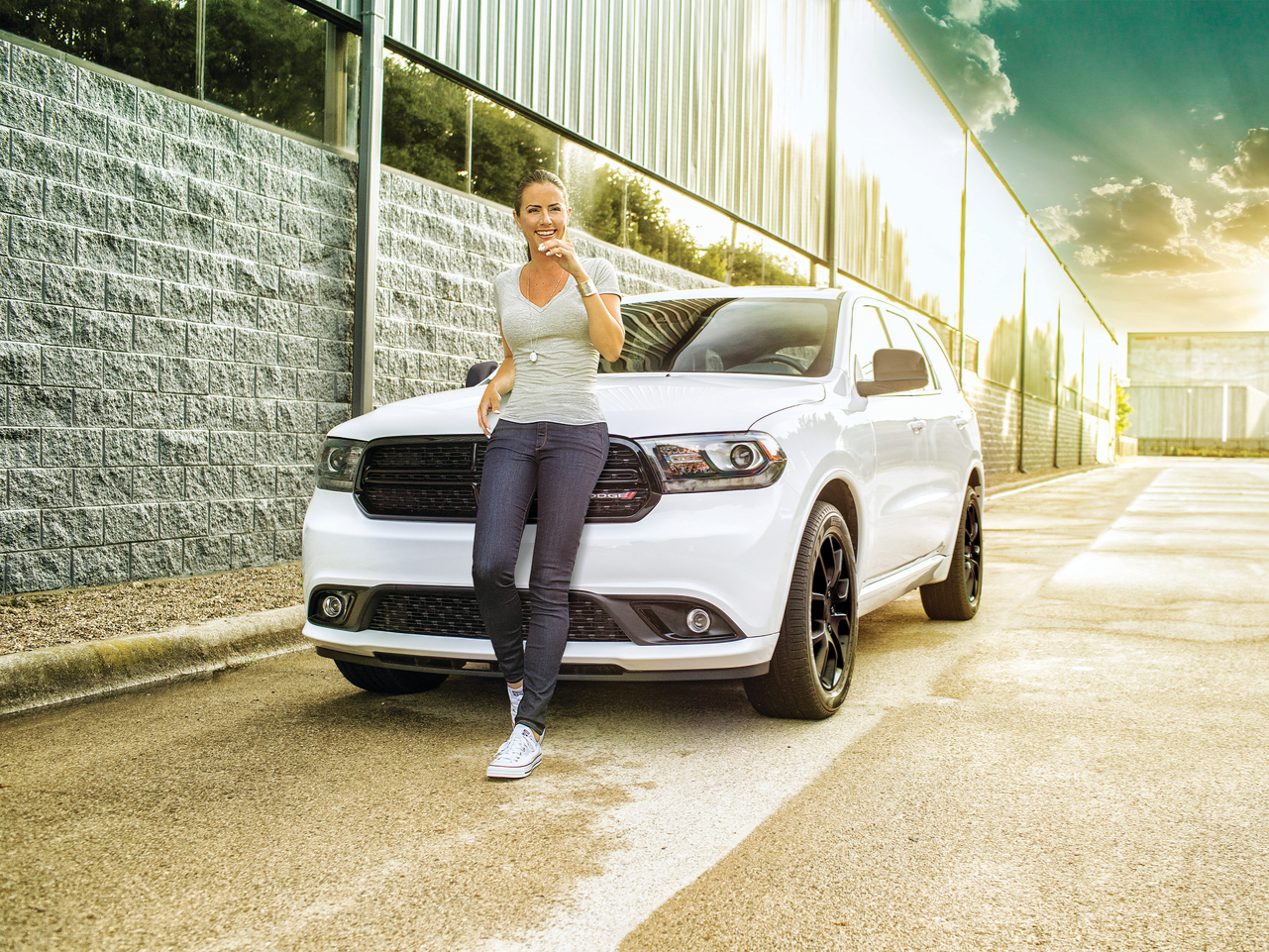 Young girl enjoying herself a cup of coffee in front of a Dodge vehicle
