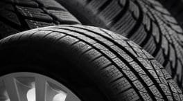 Close-up of vehicle tire tread and an alloy wheel representing Tire and Wheel Road Hazard Protection