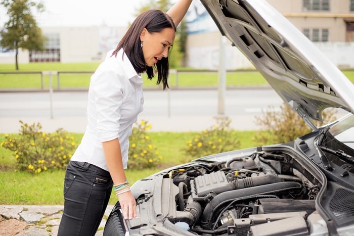 Woman_Looking_Under_Hood_Of_Car.jpg