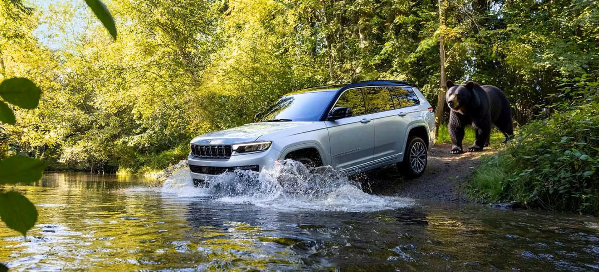 2026 Jeep Grand Cherokee fording water in the forest