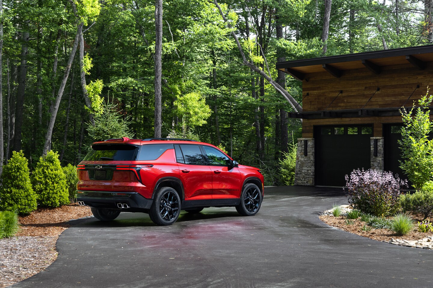 Rear and side view of a red Chevy Traverse parked in a driveway