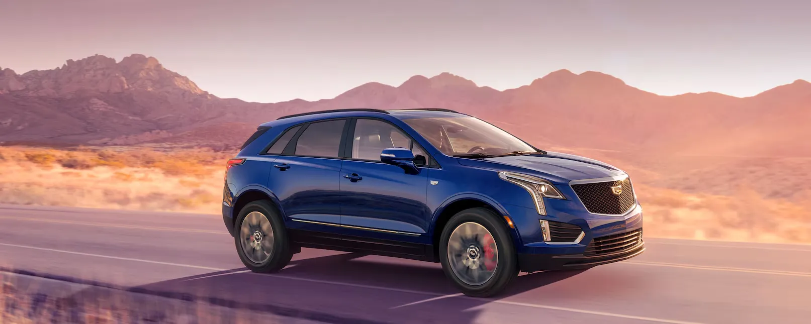 The 2026 Cadillac XT5 Driving Through a Western Landscape During Golden Hour