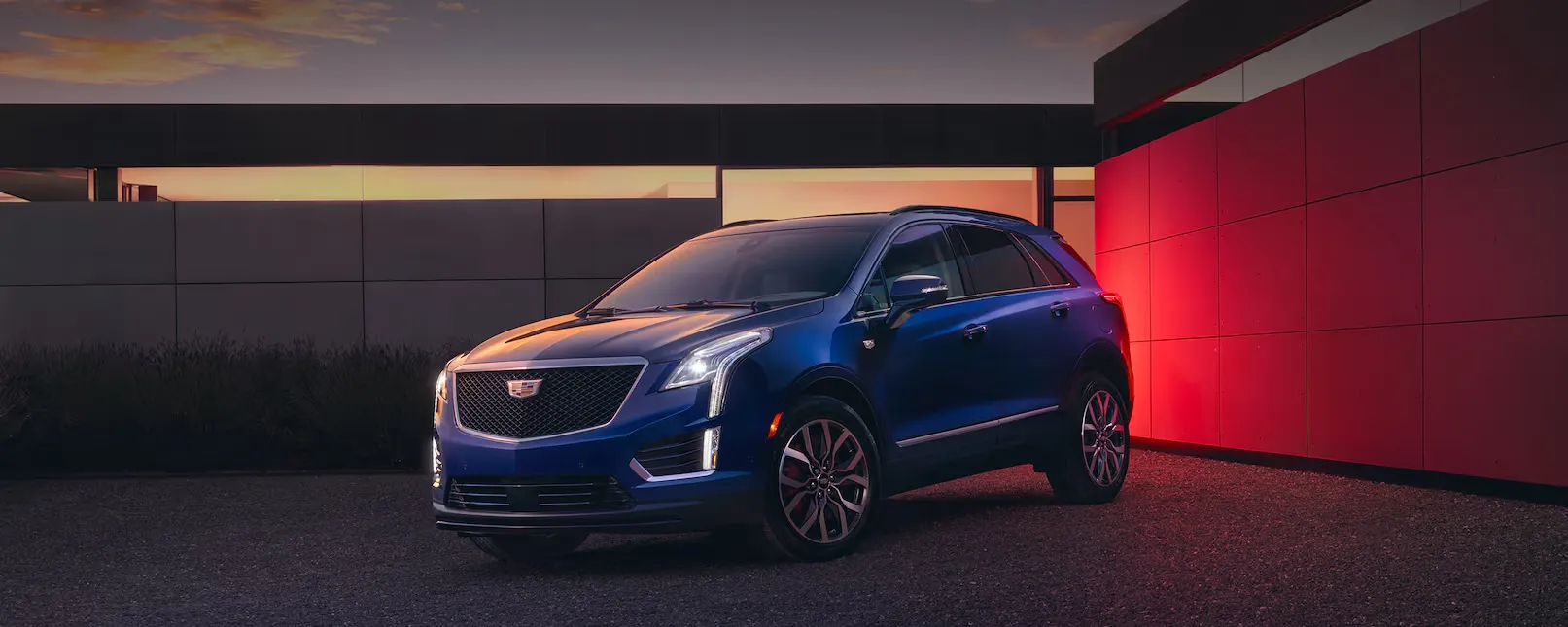 The Beautiful 2026 Cadillac XT5 Parked at Dusk in Front of Modern House With Lights On