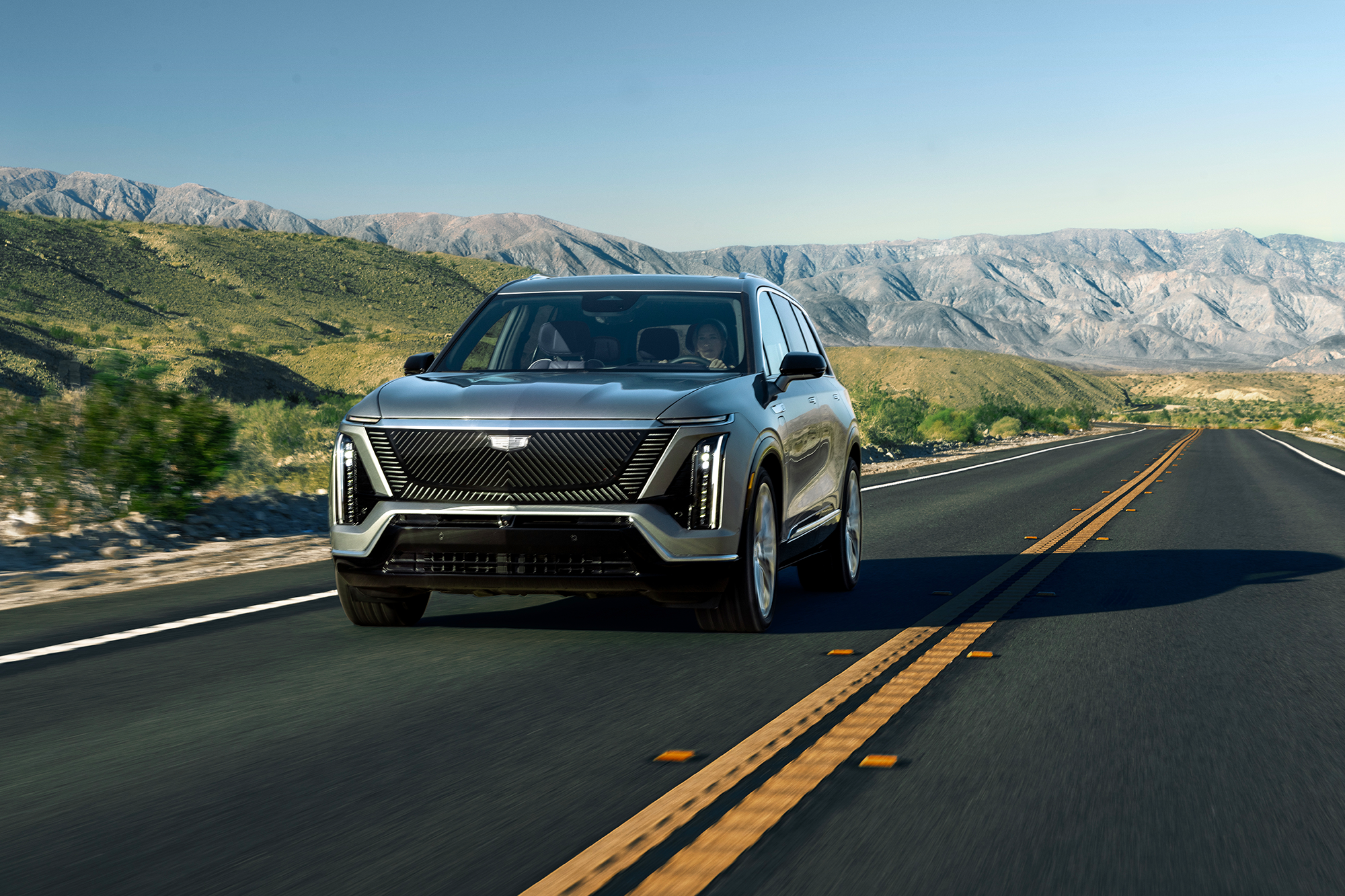 The 2026 Cadillac VISTIQ All-electric SUV Driving Down a Road  in the Mountains 