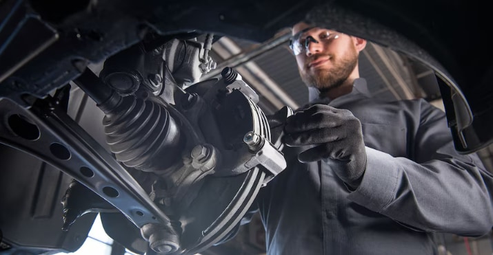 A certified Cadillac technician examines the brake fitting on a vehicle