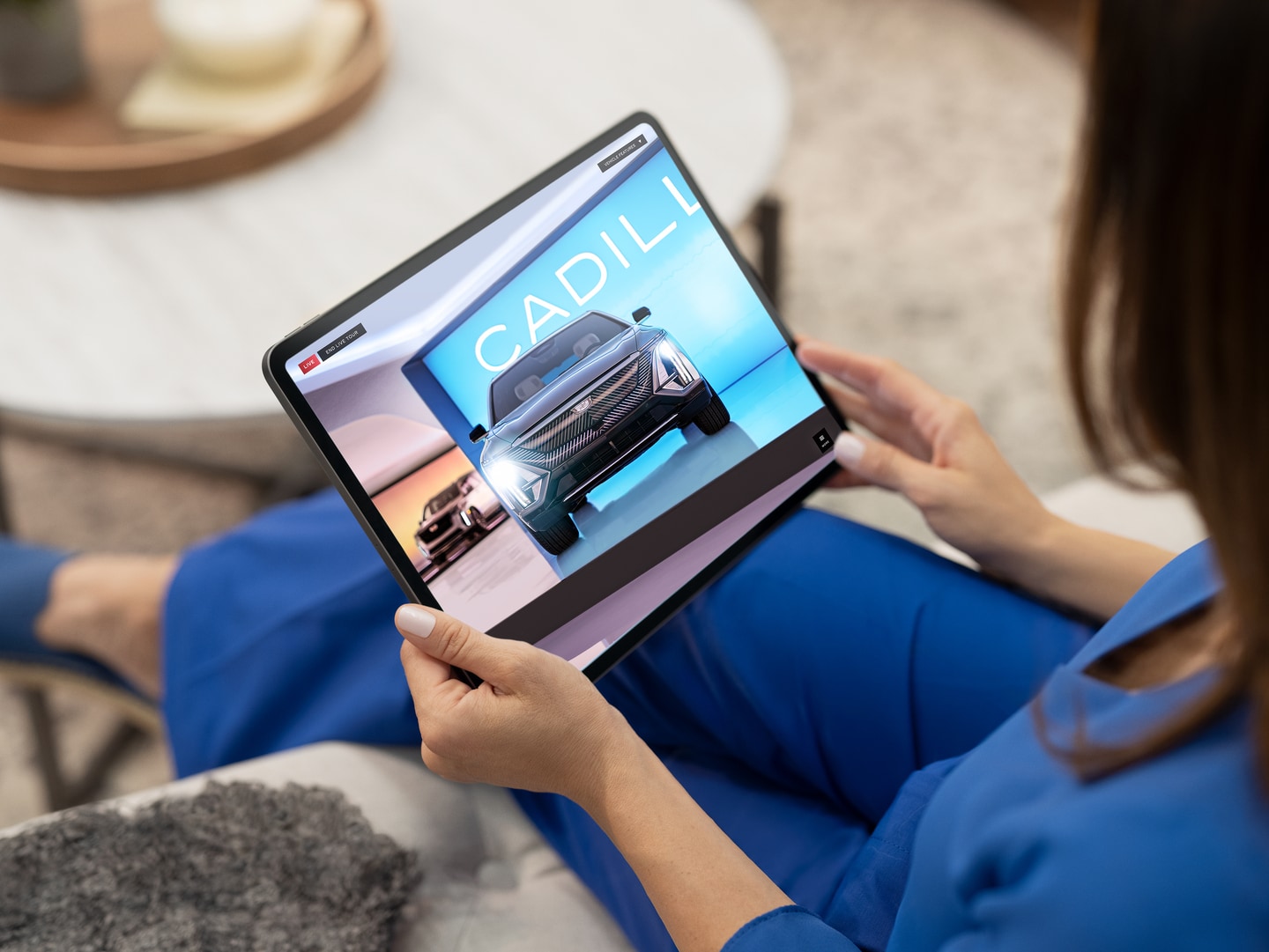 Women shopping Cadillac vehicles on tablet at home