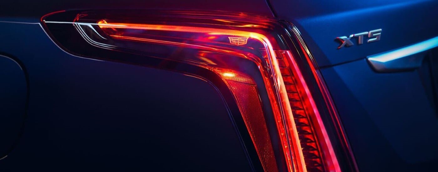 A close up shows the driver side taillight on a blue 2024 Cadillac XT5 for sale.