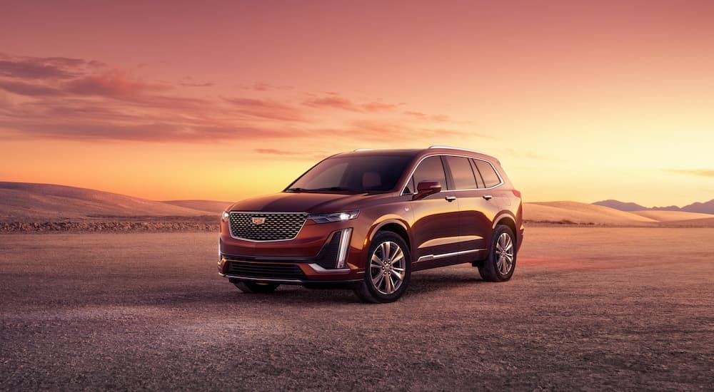 A red 2024 Cadillac XT6 is shown from the front at an angle after leaving a dealer that has a Cadillac XT6 for sale.