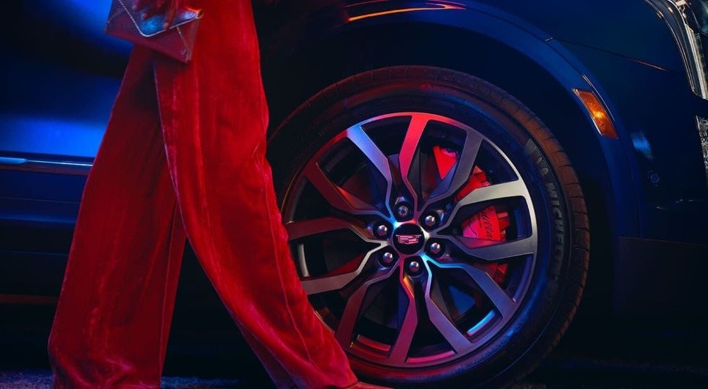 A close up shows the chrome rim on a blue 2024 Cadillac XT5.