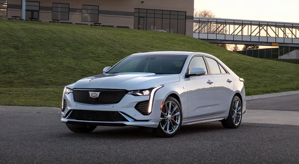 A white 2023 Cadillac CT4 is shown driving on an road after leaving a Cadillac Dealer in New York City.