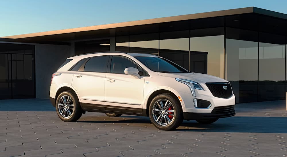 A white 2023 Cadillac XT5 is shown parked in front of a building after leaving a Cadillac dealer.