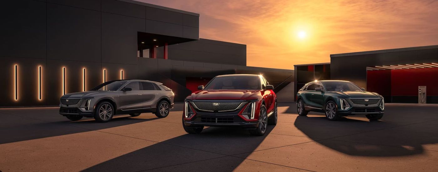 A grey, a red, and a green 2024 Cadillac LYRIQ are shown parked on a driveway.