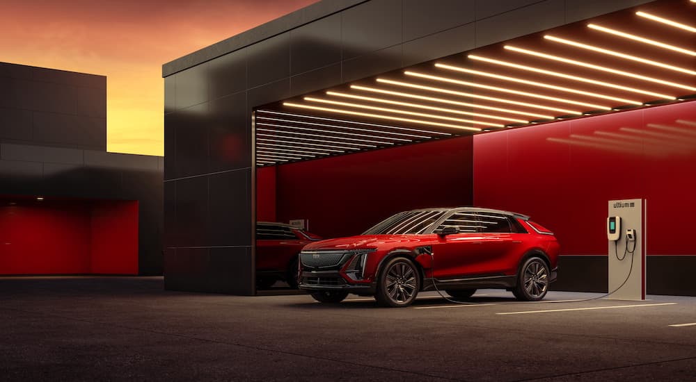 A red 2024 Cadillac LYRIQ is shown from the front at an angle while charging.