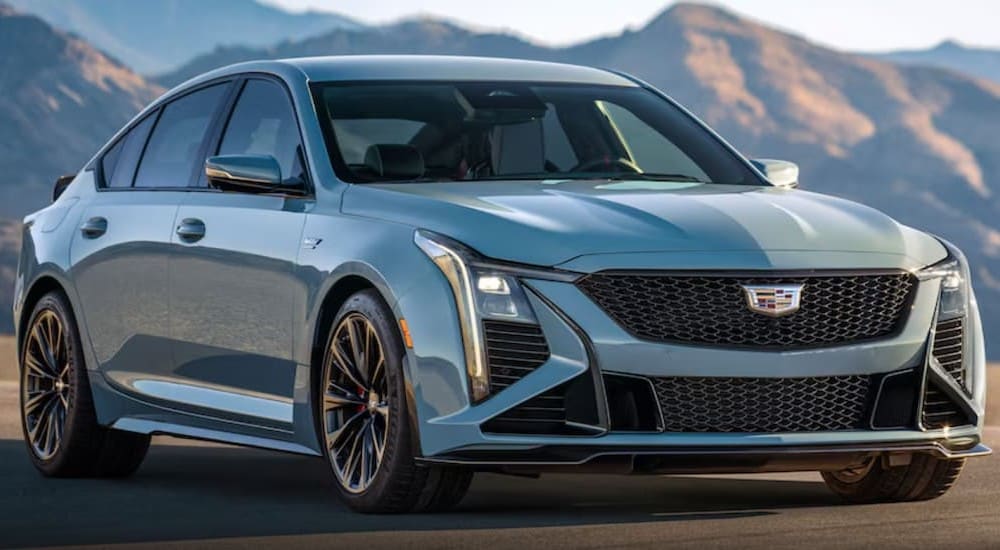 A light blue 2025 Cadillac CT5-V is shown parked near mountains.
