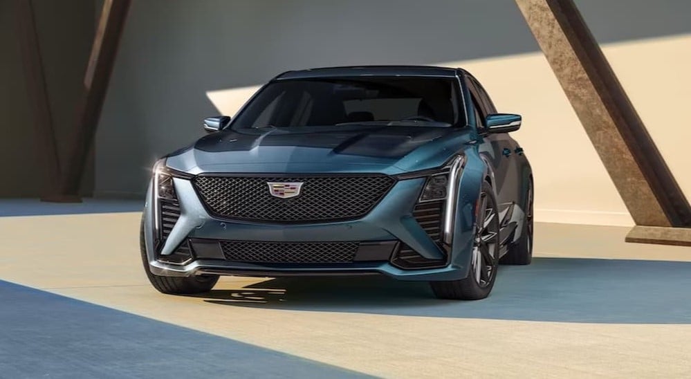 A green 2025 Cadillac CT5 is shown parked near a Cadillac dealer near Great Neck.
