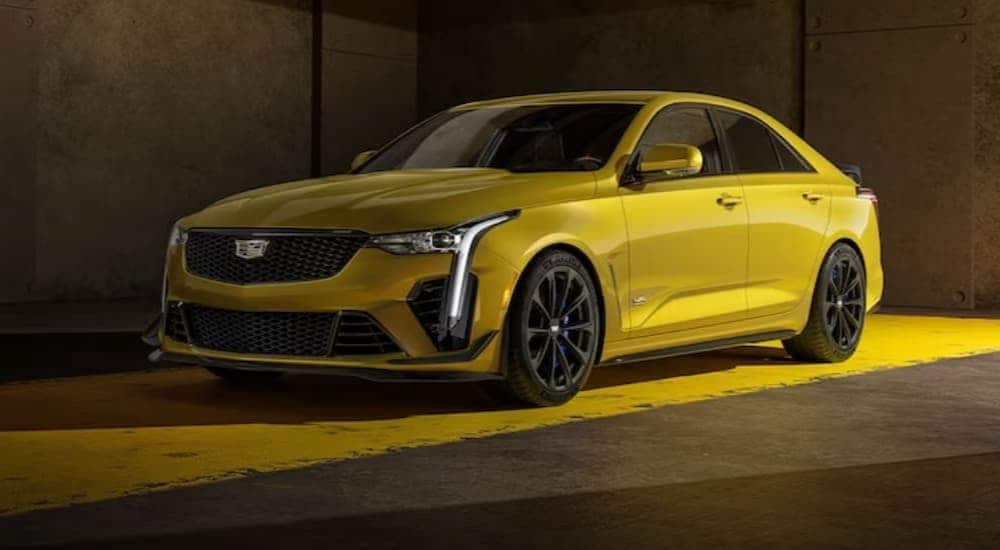 A yellow 2024 Cadillac CT4-V Blackwing is shown parked on a yellow line after visiting a Cadillac dealer near Queens.