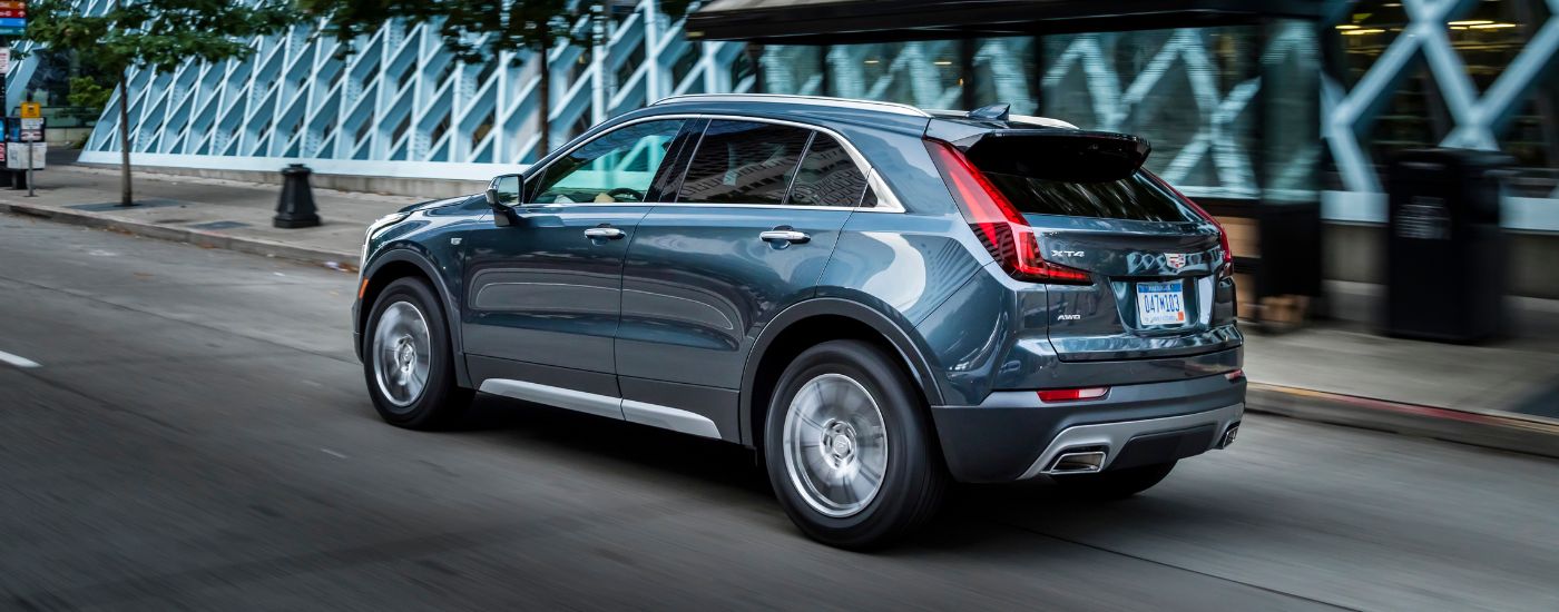 A blue 2019 Cadillac XT4 is shown driving on a city street