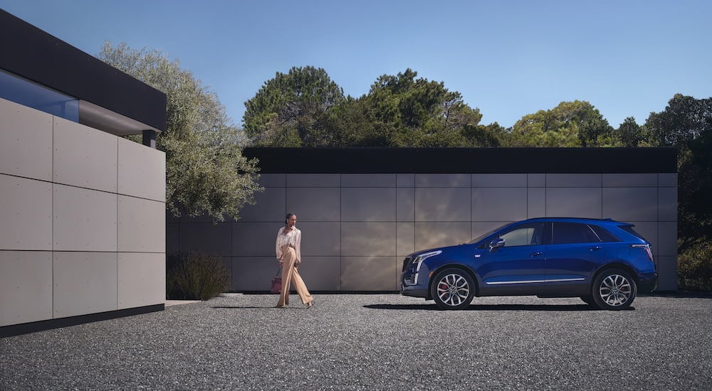 A blue 2024 Cadillac XT5 for sale near Harlem is shown from the side.