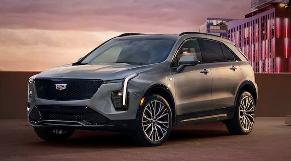 A silver 2024 Cadillac XT4 for sale near the Bronx is shown parked near a building.