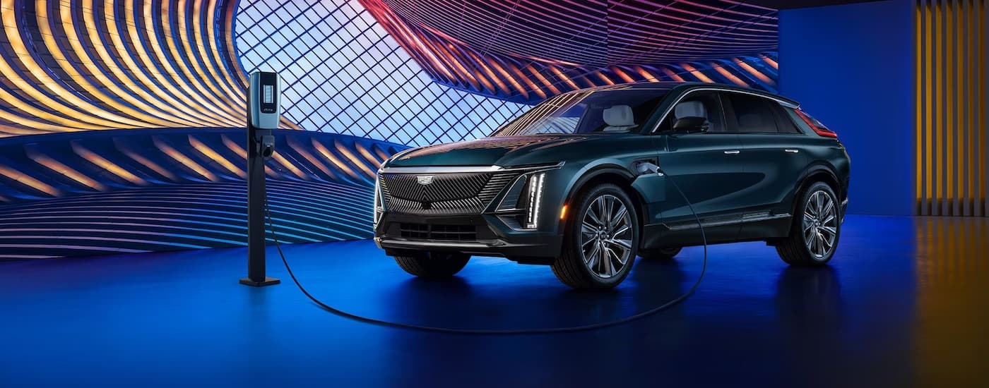 A dark green 2024 Cadillac LYRIQ angled left and parked on a show stage.