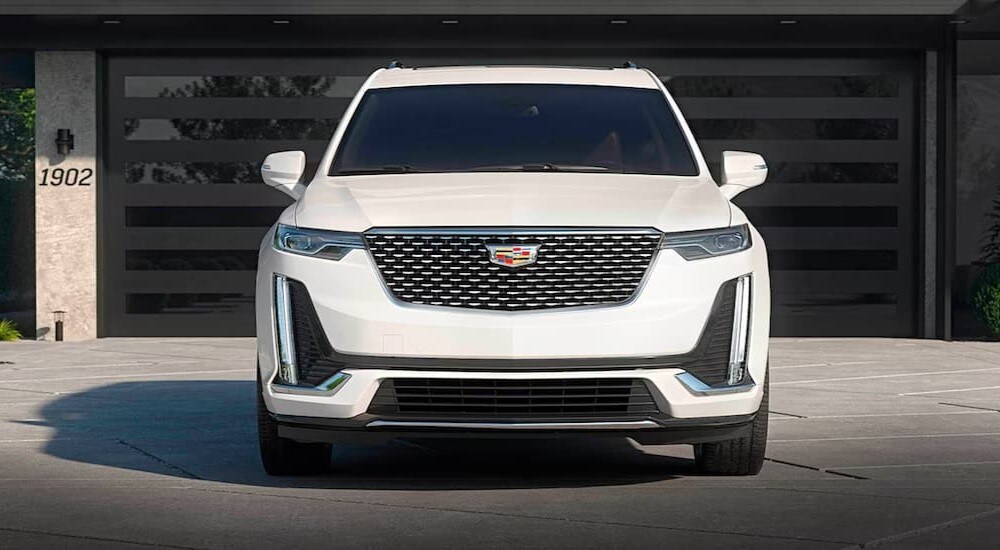 A white 2024 Cadillac XT6 is shown parked on a driveway.