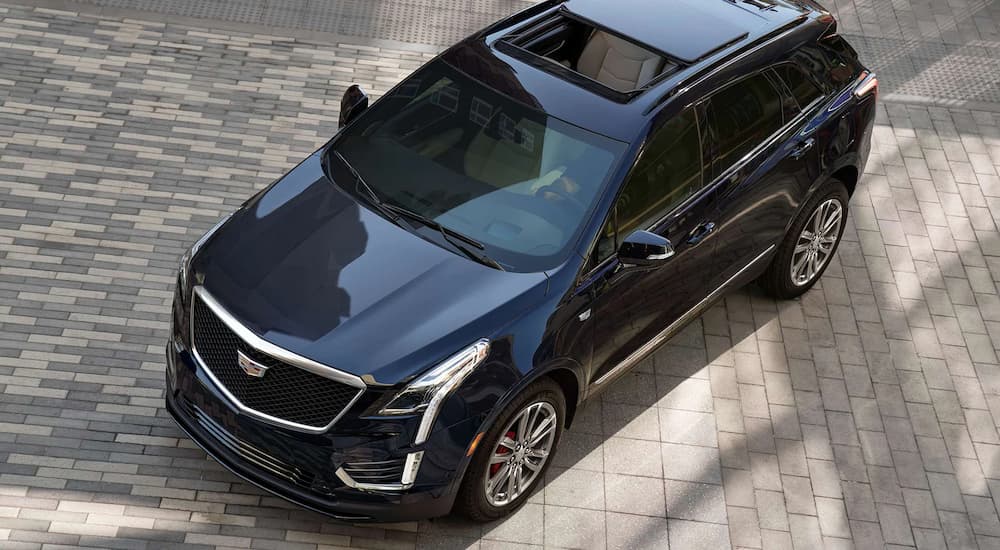A dark blue 2022 Cadillac XT5 is shown from above parked at a Cadillac dealer.