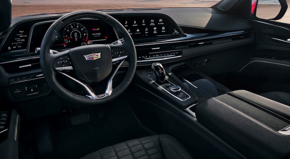 The black interior of a 2024 Cadillac Escalade V is shown from the driver's side.