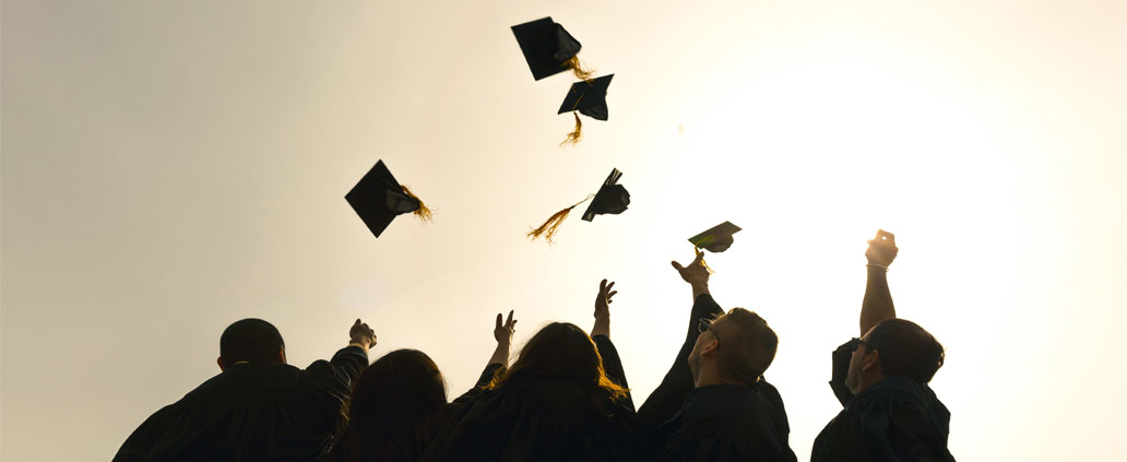 College Graduates Throwing Graduation Caps