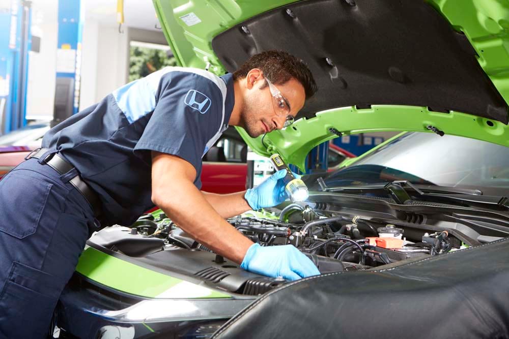 Honda certified technician inspecting vehicle engine