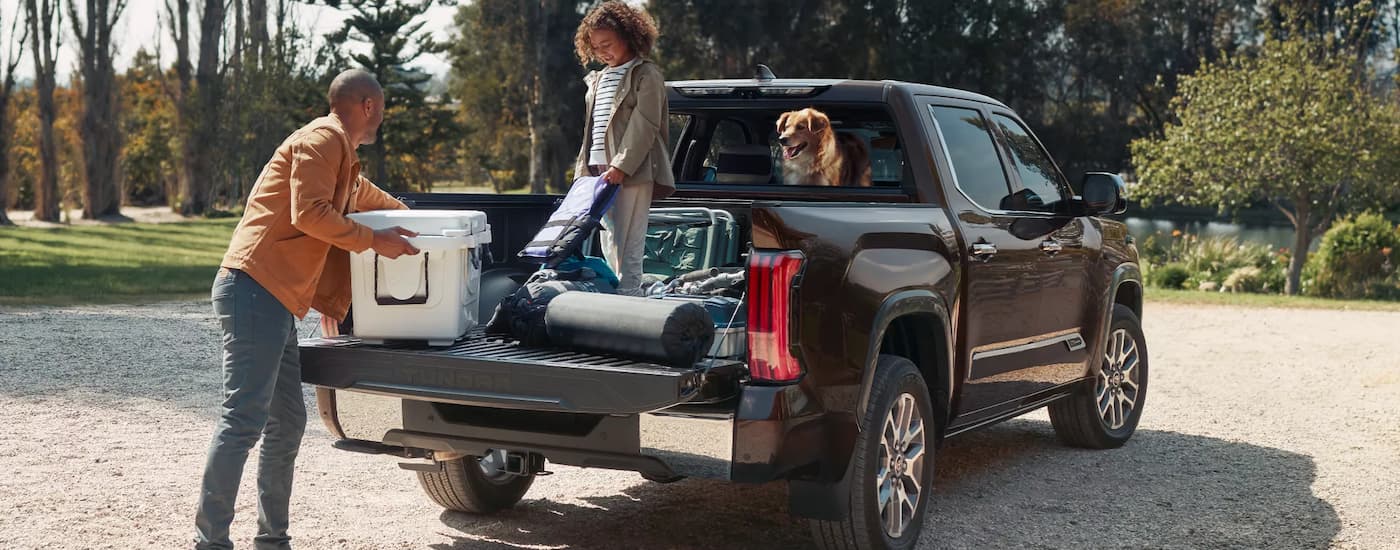 A family is putting cargo into the bed of a 2022 Toyota Tundra.