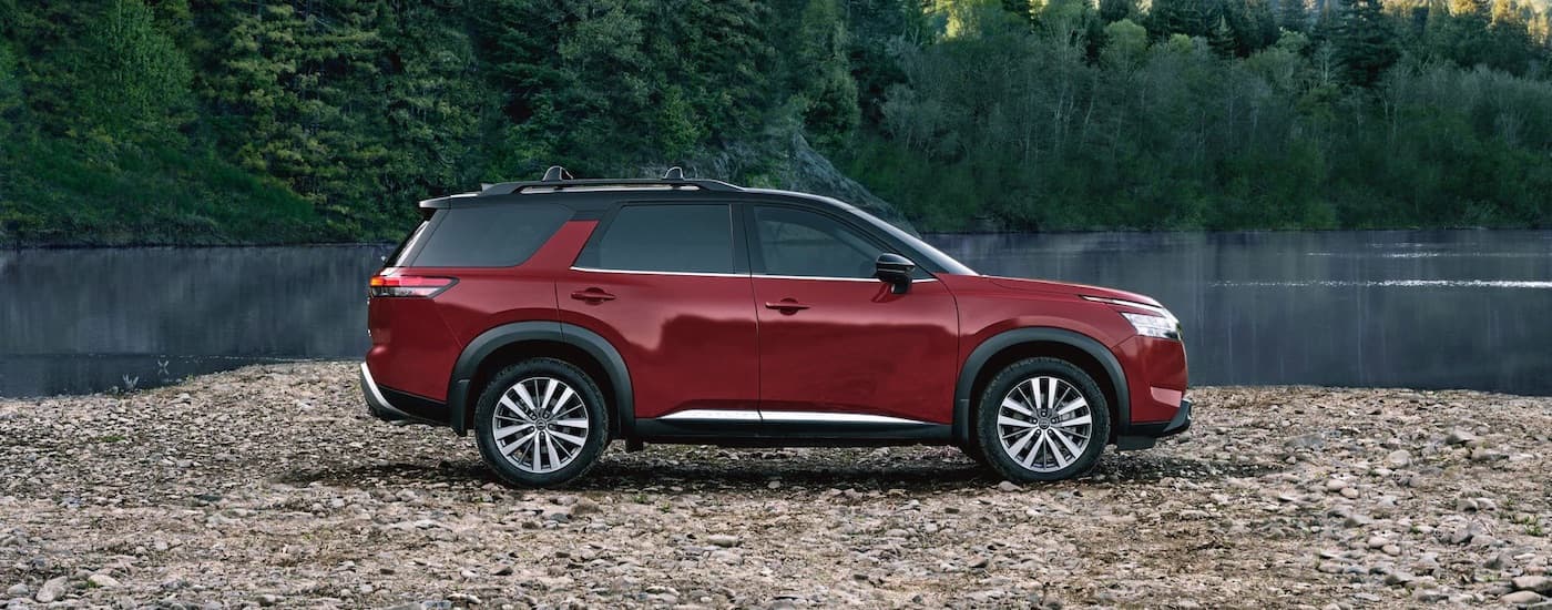 A red 2022 Nissan Pathfinder from the side.