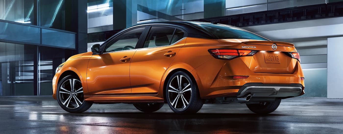 An orange 2023 Nissan Sentra from the side after leaving a used car dealer near Biloxi.