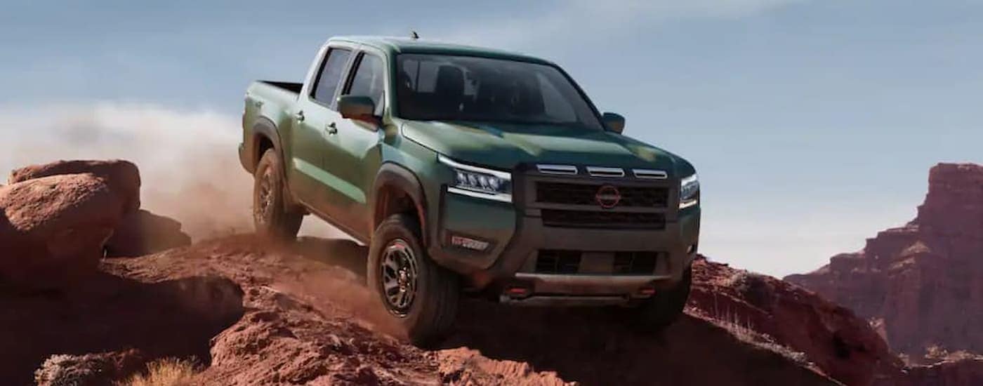 A green 2025 Nissan Frontier off-roading for sale near Pascagoula