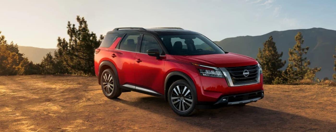 A red 2023 Nissan Rogue from the side.