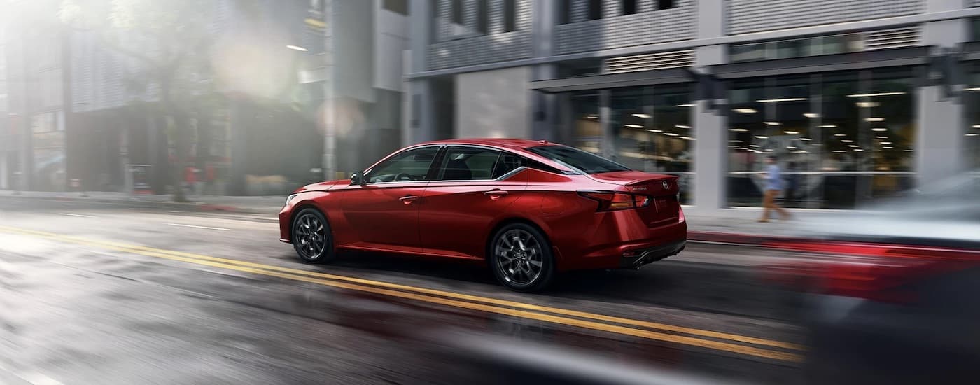 A red 2023 Nissan Altima from the side after leaving a dealer that has a used Nissan for sale near Biloxi.
