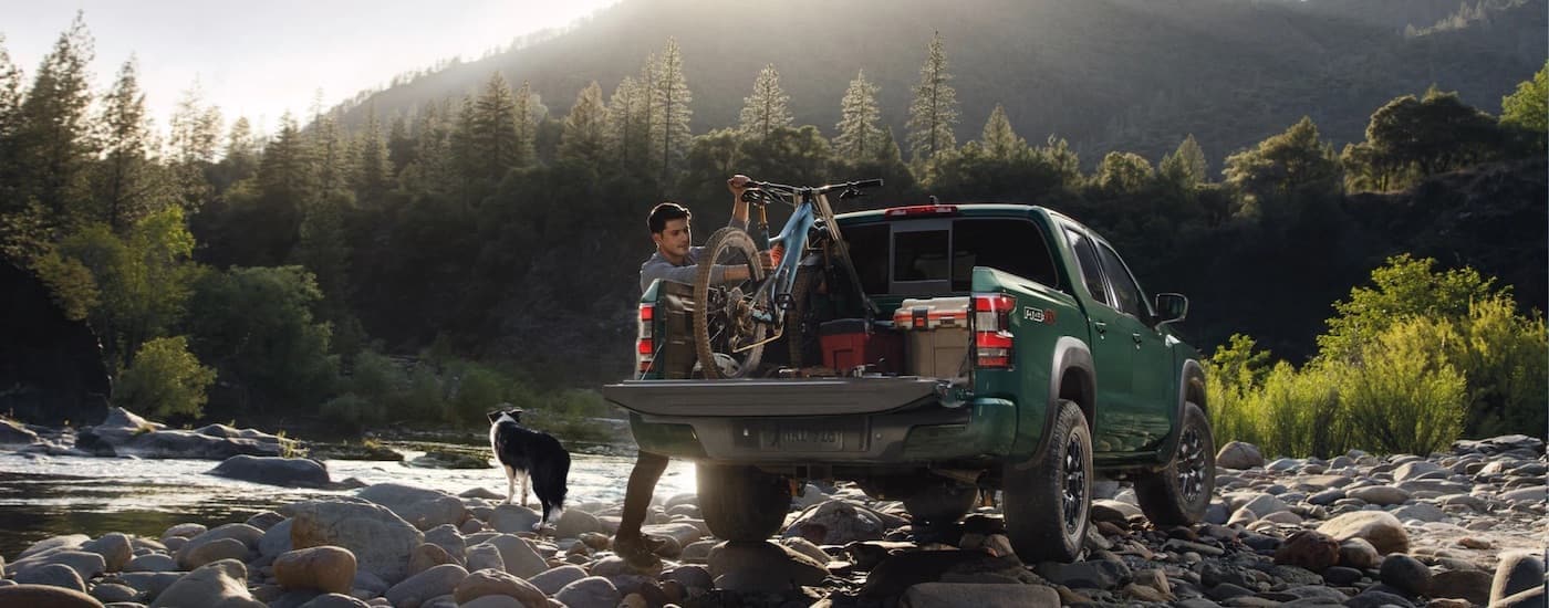 A green 2023 Nissan Frontier from the rear.