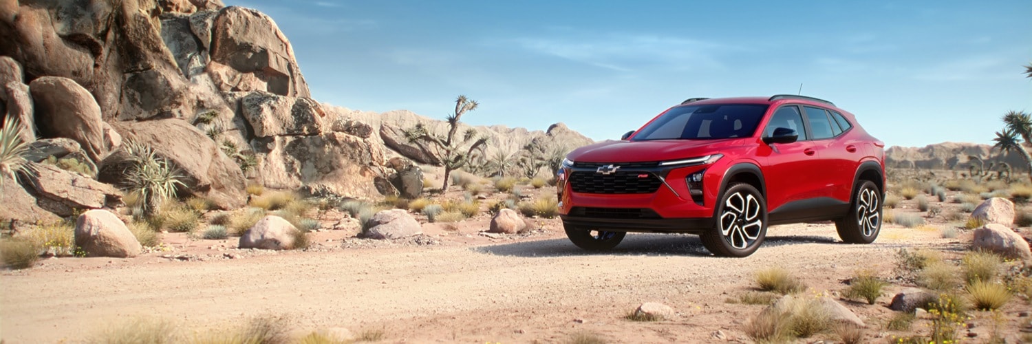 Red Chevy Trax parked on street with 
colorful buildings